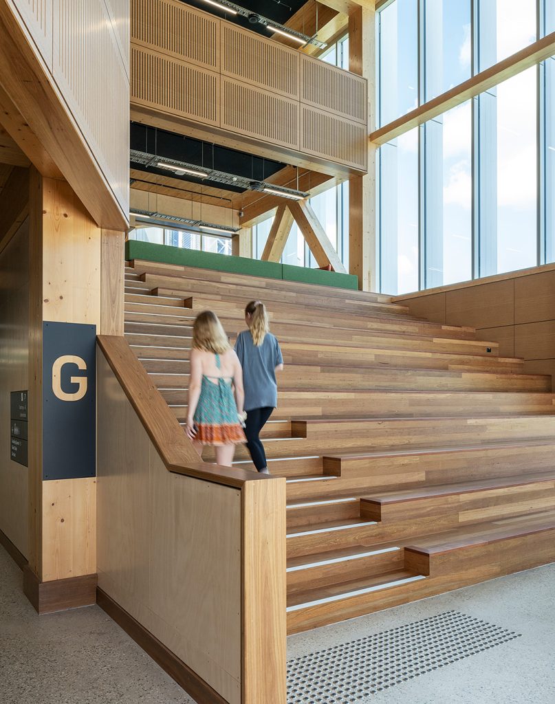 Students walking up the feature stairs, with level ID wayfinding visible.